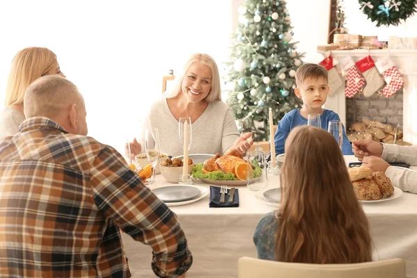 Glad familj som äter julmiddag hemma — Stockfoto