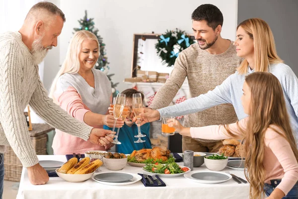 Feliz familia tintineo vasos durante la cena de Navidad en casa —  Fotos de Stock