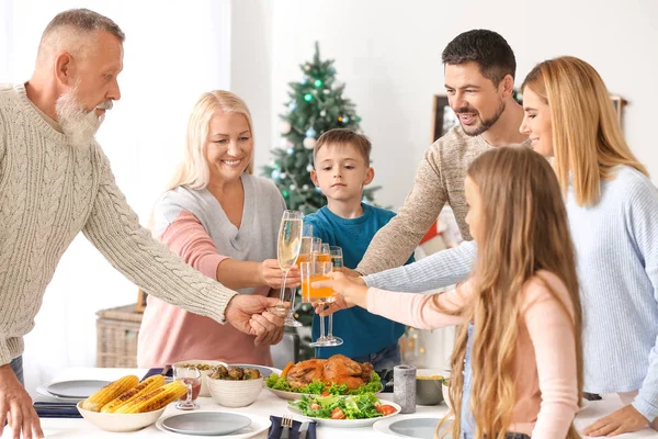 Szczęśliwa rodzina sakiewkach brzęczały okulary podczas świąteczny obiad w domu — Zdjęcie stockowe