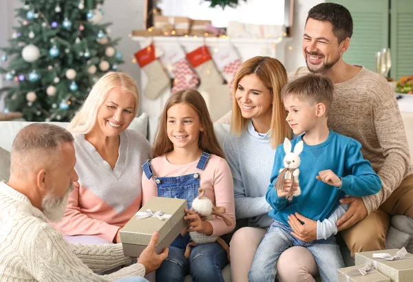 Liten flicka som tar emot julklapp från hennes farfar hemma — Stockfoto