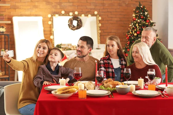 Familia feliz tomando selfie durante la cena de Navidad en casa — Foto de Stock