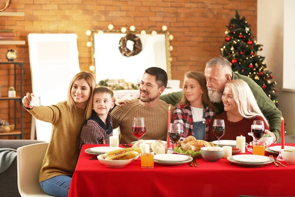 Happy family taking selfie during Christmas dinner at home — Stock Photo, Image