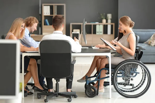 Mujer joven discapacitada con colegas que trabajan en la oficina — Foto de Stock