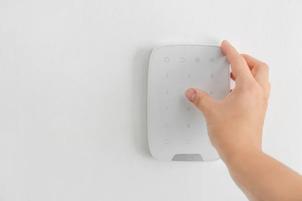 Woman entering code on panel of modern security system — Stock Photo, Image