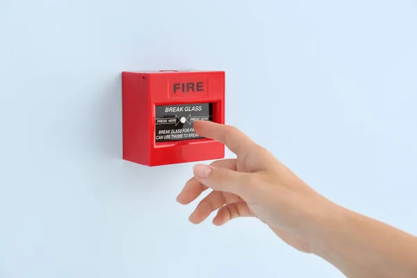Женщина с помощью ручного вызова системы пожарной сигнализации — стоковое фото