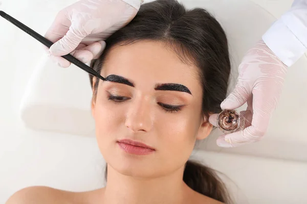 Jonge vrouw ondergaan wenkbrauw correctie procedure in schoonheidssalon — Stockfoto