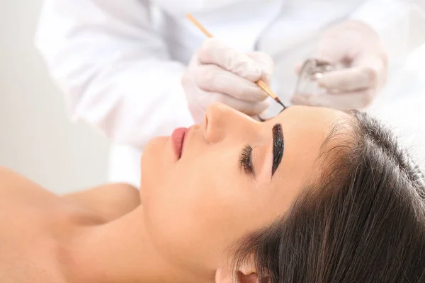 Jonge vrouw ondergaan wenkbrauw correctie procedure in schoonheidssalon — Stockfoto