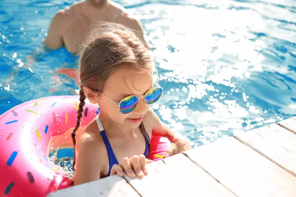 Menina bonito com anel inflável na piscina — Fotografia de Stock