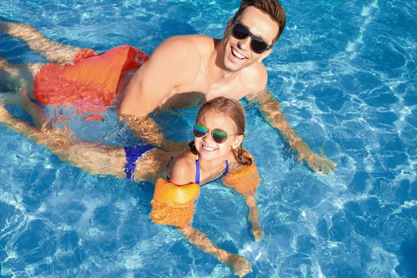 Pai com menina na piscina no dia de verão — Fotografia de Stock