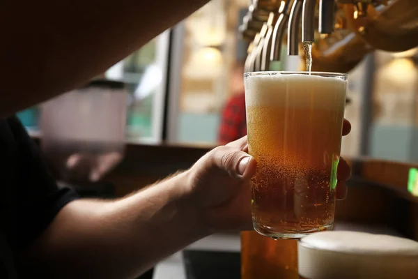 Barman pouring fresh beer in glass, closeup — Stock Photo, Image