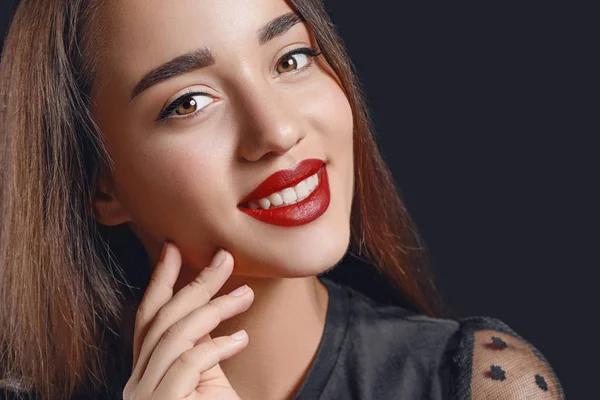 Beautiful young woman with bright lipstick on dark background — Stock Photo, Image
