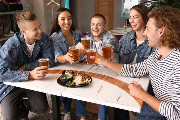 Vänner dricker färskt öl i pub — Stockfoto