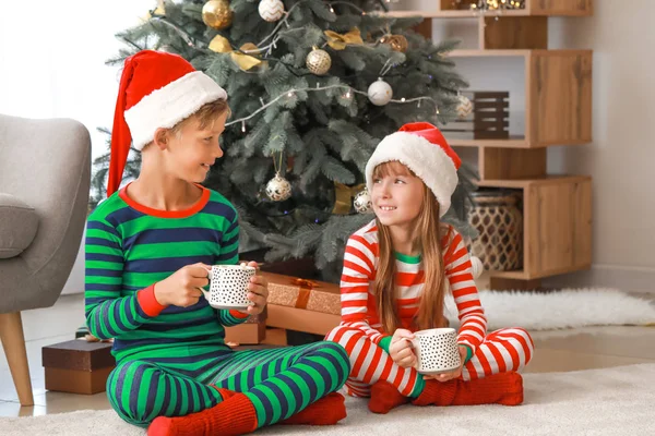 Crianças bebendo chocolate quente em casa na véspera de Natal — Fotografia de Stock