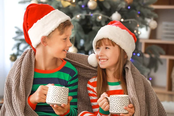 Crianças bebendo chocolate quente em casa na véspera de Natal — Fotografia de Stock