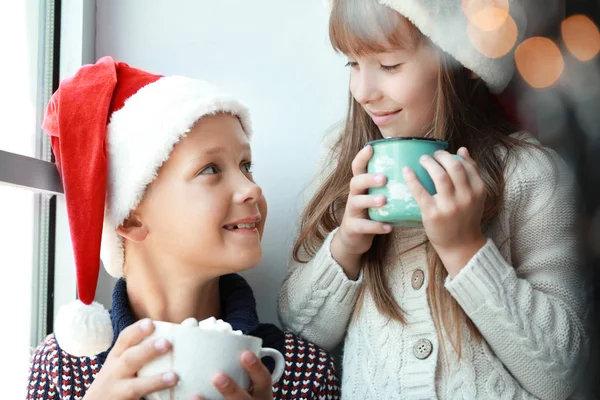 Niños bebiendo chocolate caliente en casa en Nochebuena — Foto de Stock