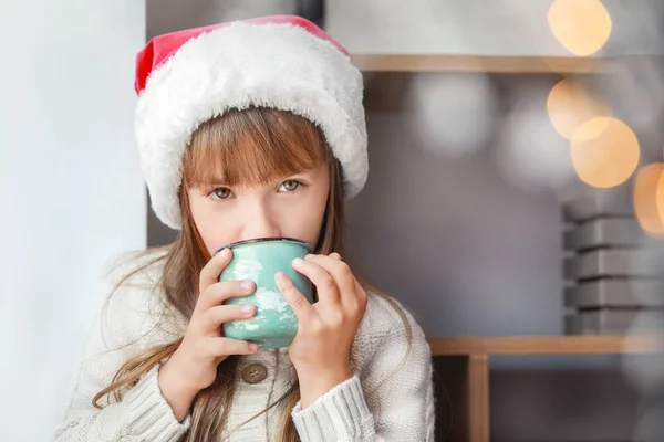 Petite fille buvant du chocolat chaud à la maison la veille de Noël — Photo