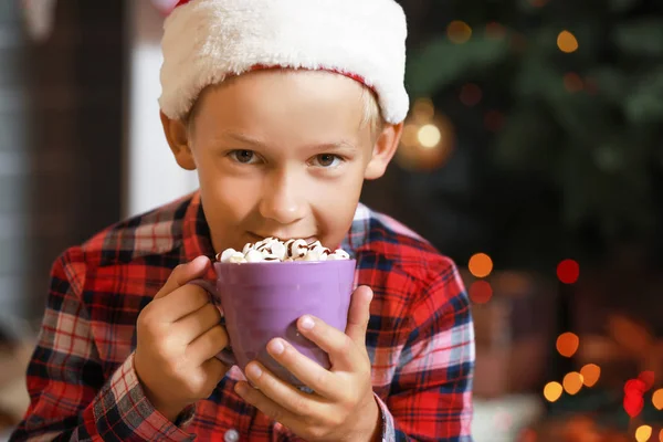 Menino bebendo chocolate quente em casa na véspera de Natal — Fotografia de Stock