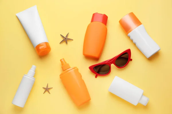 Diferentes cremas de protección solar y gafas de sol sobre fondo de color — Foto de Stock