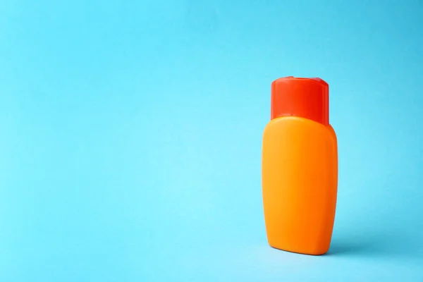 Bottle of sun protection cream on color background — Stock Photo, Image