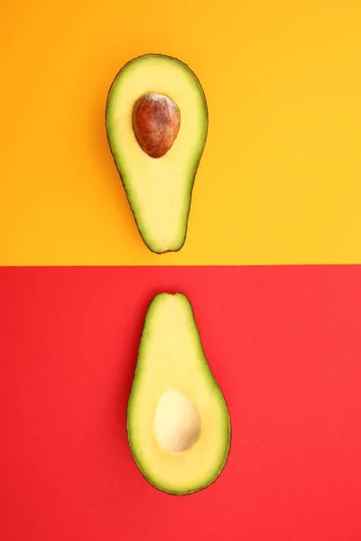 Halves of ripe avocado on color background — Stock Photo, Image