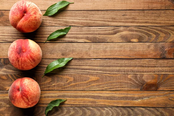 Стиглі персики на дерев'яному фоні — стокове фото