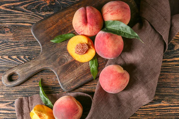 Ripe juicy peaches on wooden background