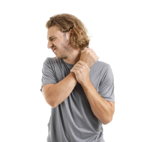 Young man suffering from pain in wrist on white background — Stock Photo, Image