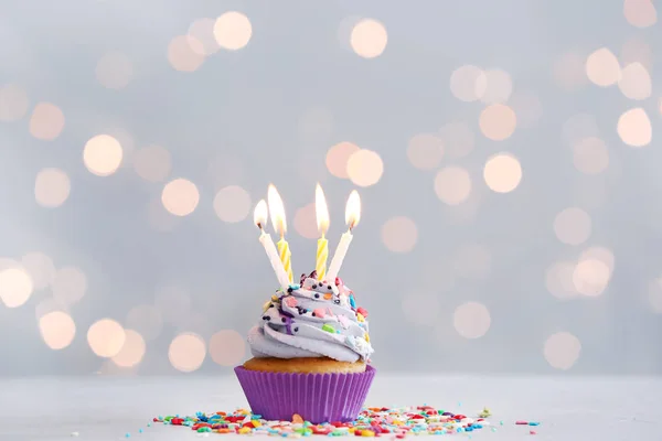 Gustos cupcake ziua de naștere pe masă împotriva luminilor defocalizate — Fotografie, imagine de stoc