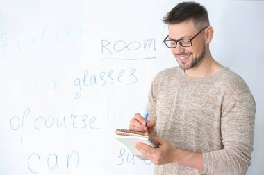 Sınıfta tahta yakın deftere yazma yakışıklı erkek öğretmen