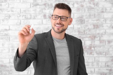 Tuğla duvara karşı tebeşir ile Yakışıklı erkek öğretmen