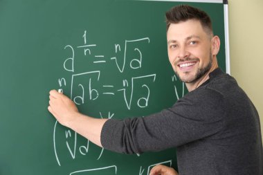 Yakışıklı matematik öğretmeni sınıfta tahtaya yazma
