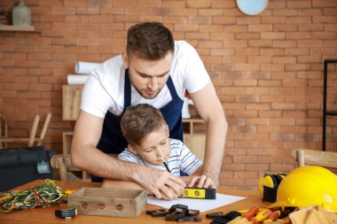 Babamın küçük oğlunu evde araçlarla idare etmesini öğreterek