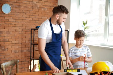 Babamın küçük oğlunu evde araçlarla idare etmesini öğreterek