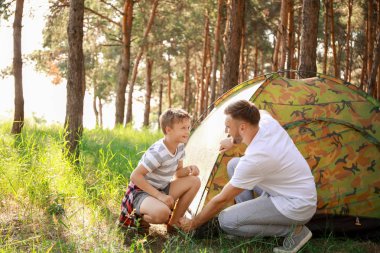 Baba ve küçük oğlu ormanda kamp çadır koyarak