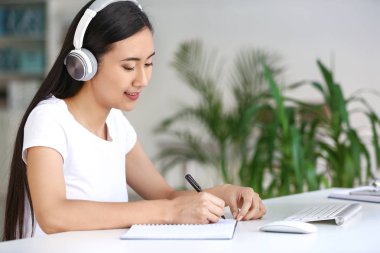 Sınava hazırlanırken müzik dinleyen genç Asyalı öğrenci