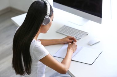 Sınava hazırlanırken müzik dinleyen genç Asyalı öğrenci