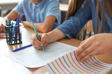 Sınıfta okul testi sırasında kopya çeken genç kız