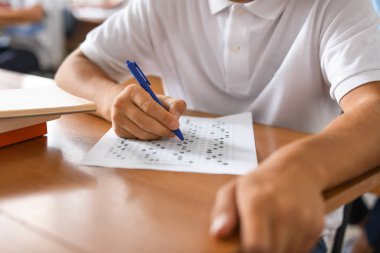 Sınıfta okul testini geçen genç çocuk