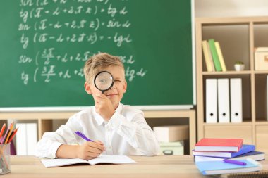 Sınıfta ev ödevi yapan küçük çocuk