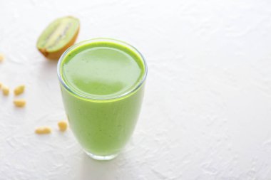 Beyaz masada kivi ve fındık ile sağlıklı smoothie Cam