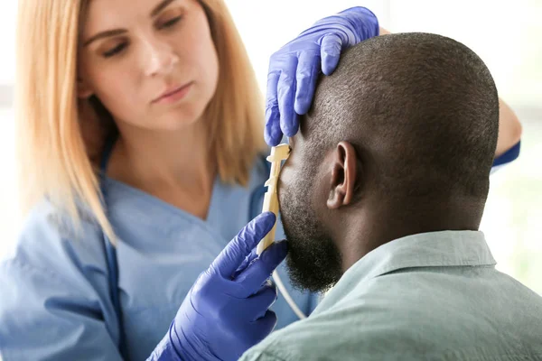 African-American man meeting with plastic surgeon before operation in clinic — Stock Photo, Image