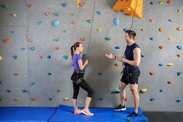 Joven hombre y mujer en gimnasio de escalada — Foto de Stock