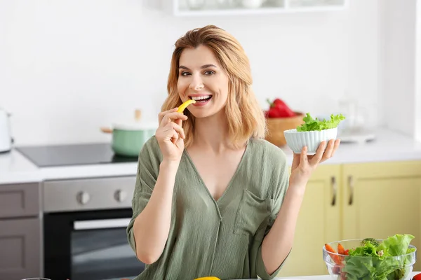 Frau mit gesundem Gemüsesalat in der Küche — Stockfoto