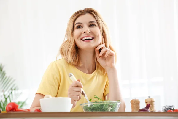 Mulher com salada de legumes saudável na cozinha — Fotografia de Stock