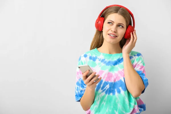 젊은 여성이 밝은 배경에서 오디오 북 듣기 — 스톡 사진