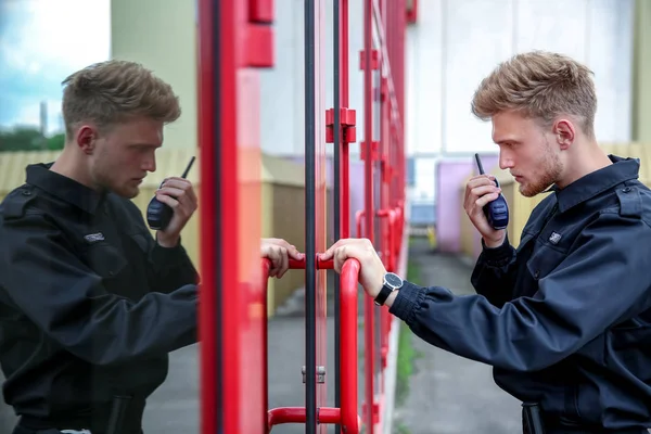 Handsome male security guard opening entrance door — Stock Photo, Image