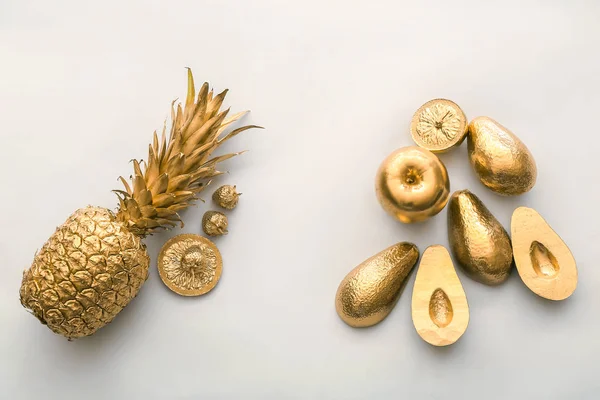 Golden tropical fruits on light background — Stock Photo, Image