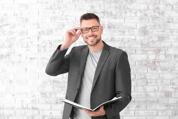 Bonito professor masculino contra parede de tijolo — Fotografia de Stock