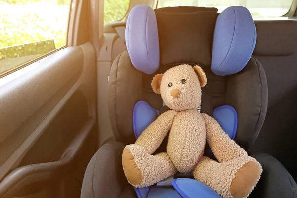 Toy bear on car safety seat