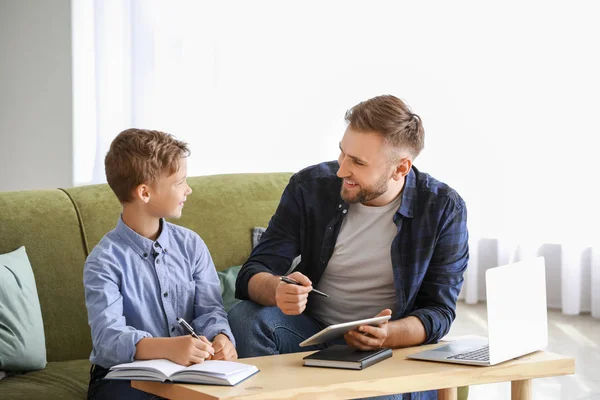 Ο πατέρας βοηθάει το γιο του να κάνει μαθήματα στο σπίτι. — Φωτογραφία Αρχείου